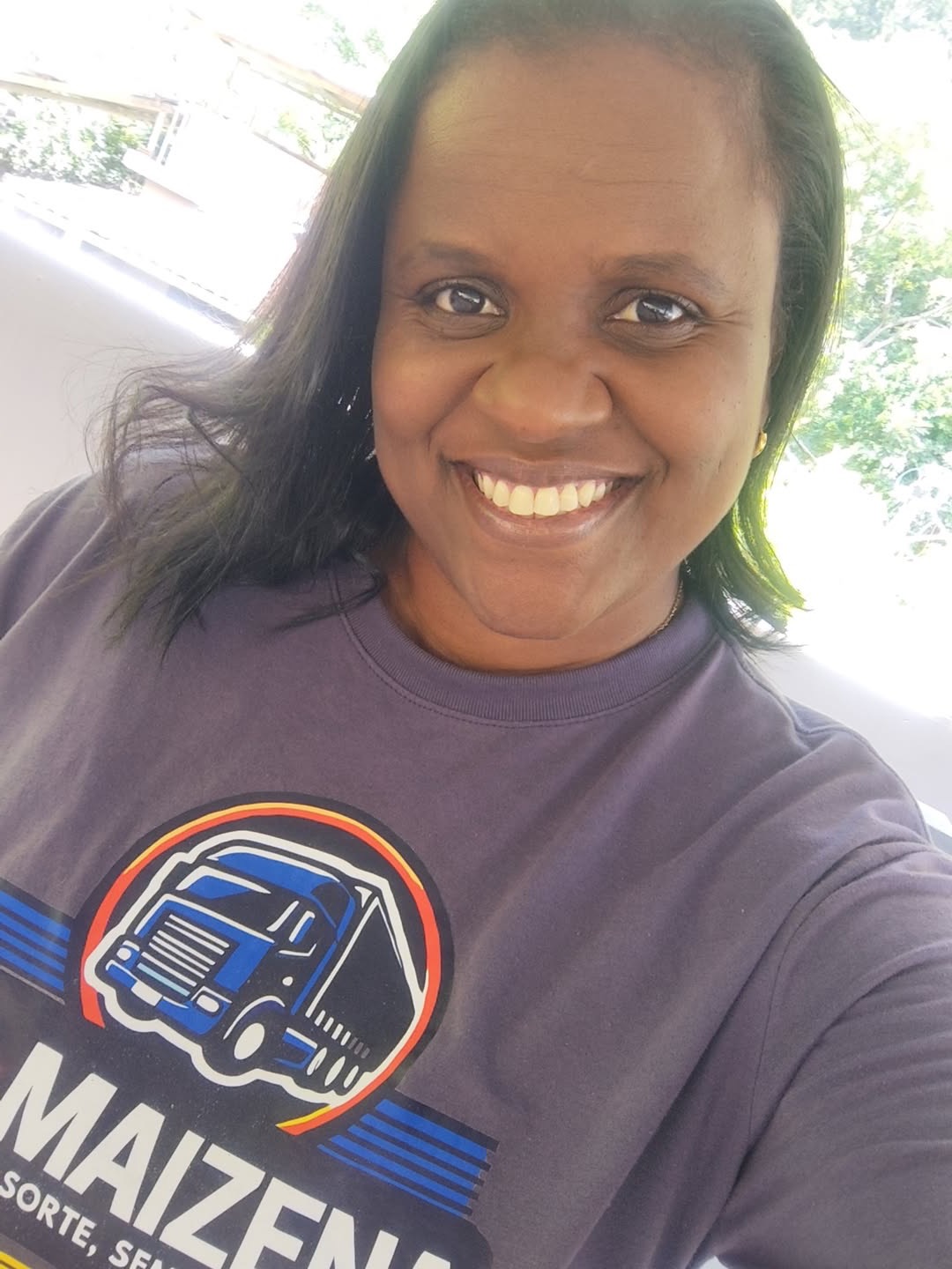 Jayne Floriano, sócia-gestora da TR Maizena, sorrindo com a camiseta da transportadora